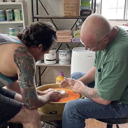 Instructor and student at pottery wheel
